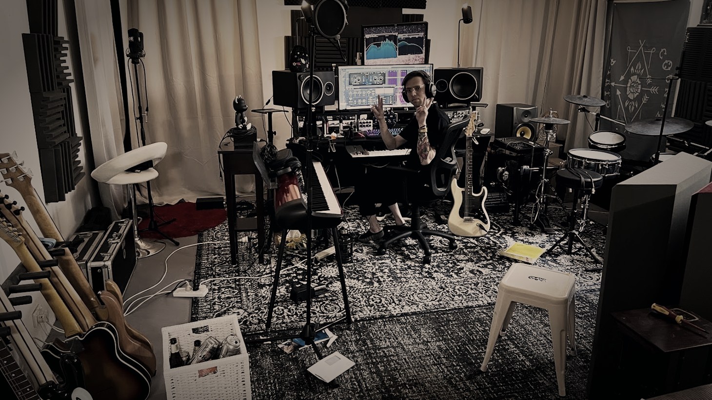 Jacob Wilkes at the desk in his Sydney studio, guitars racked and drums behind him